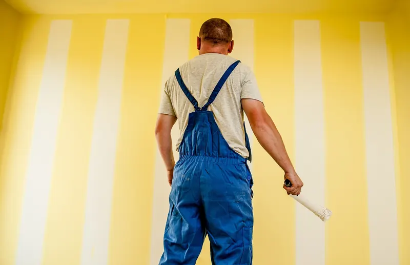Maler beim Anstrich einer Wand in einem Gemeinschaftsbereich